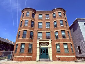 Exterior four story brick building, Green entrance door photo taken from street.
